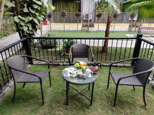 卡兰古特Kyriad Prestige Calangute Goa by OTHPL的两张椅子和一张桌子,上面有杯子和鲜花