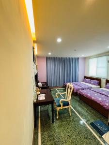 Xingang番路乡居民宿的一间卧室配有两张床、一张桌子和一张桌子