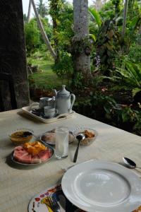 阿杭格默Rasara Home Stay的餐桌,带盘子和茶壶