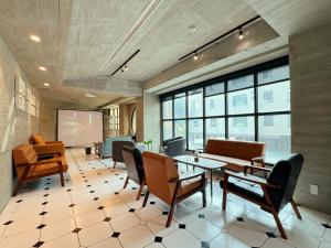 台南Roaders Hotel Tainan ChengDa的一间会议室,配有椅子、桌子和屏幕