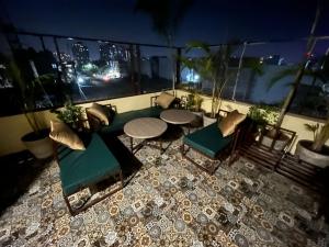 印多尔Kasa Comfort Inn的阳台的天井配有桌椅