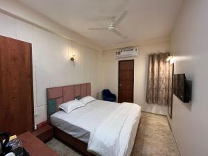 印多尔Kasa Comfort Inn的卧室配有白色的床和电视