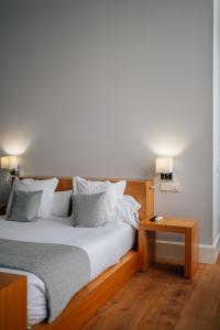 赫雷斯-德拉弗龙特拉Hotel Boutique Palacio Corredera的一间卧室配有一张大床和木制床头板