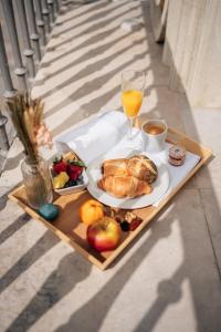 赫雷斯-德拉弗龙特拉Hotel Boutique Palacio Corredera的一张桌子,上面放着一盘食物和一杯橙汁