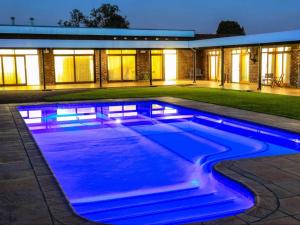 纽卡斯尔Pheasant's Rest Guest House的一座房子前方的蓝色灯光游泳池