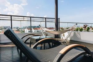 新加坡Santa Grand Hotel East Coast a NuVe Group Collection的屋顶上带椅子和吊床的阳台