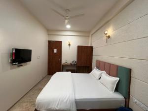 印多尔Kasa Comfort Inn的一间卧室配有一张床和一台平面电视