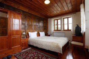 泽拉夫纳Yovina House Zheravna的一间卧室设有一张床和木镶板墙