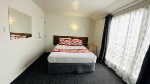 基督城Samhil Motor Lodge的一间卧室设有一张床和一个大窗户