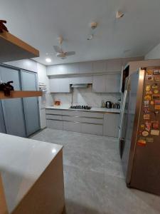 浦那Royal Nest Premium的厨房配有白色橱柜和不锈钢冰箱