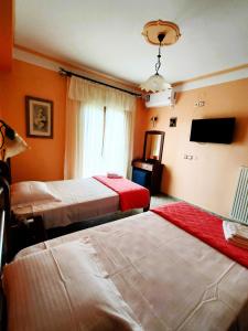 Argyrádesprestige studio & apartment的酒店客房设有两张床和电视。