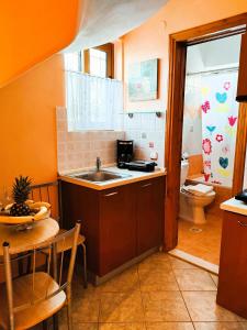 Argyrádesprestige studio & apartment的厨房配有水槽、卫生间和桌子
