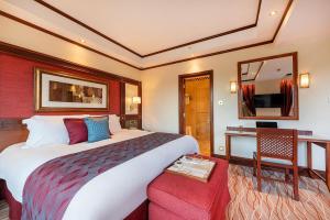 内罗毕内罗毕塞丽娜酒店的配有一张大床和镜子的酒店客房