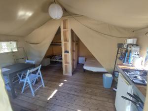 Saint-Saud-LacoussièreCamping de la Bucherie的带帐篷的房间,配有桌子和梯子