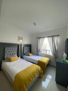 约里奇拉Acogedora y amplia casa, alberca climatizada previa reserva的卧室设有两张床,配有黄色床单和窗户