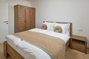 马卡尔斯卡Sun Spalato Residence的一间卧室配有一张大床和一个木制橱柜