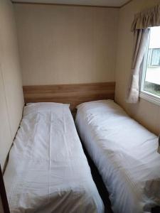 BeltonNorfolk broads caravan sleeps 8的卧室内两张并排的床
