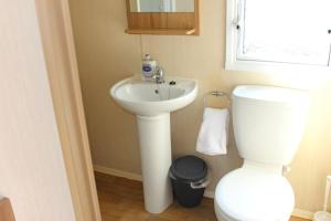 BeltonNorfolk broads caravan sleeps 8的浴室配有白色卫生间和盥洗盆。