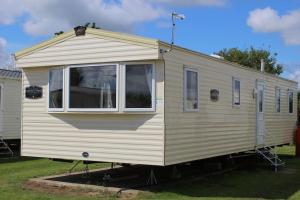 BeltonNorfolk broads caravan sleeps 8的一辆白色大篷车停在院子里