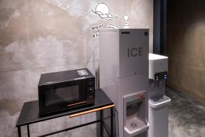 京都hotel Bell・Kyoto的制冰机旁的桌子上的微波炉