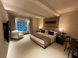 热那亚Hotel Palazzo Durazzo Suites的大型酒店客房,配有床和椅子