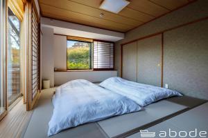 Onsensōabode villa GORA 八代別邸的一间卧室设有一张大床和窗户