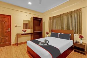 班加罗尔Super OYO Manyata Stay-In的配有一张床和一张书桌的酒店客房