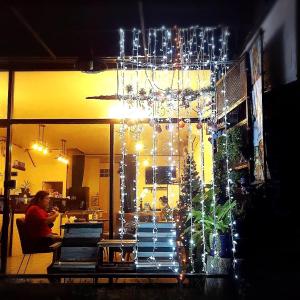 Ban Sao ThongThree Hostel at Night Market Pakchong的一间设有圣诞树和吊灯的房间