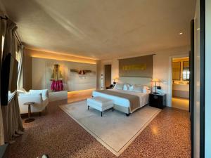 热那亚Hotel Palazzo Durazzo Suites的一间大卧室,配有一张床和一把椅子