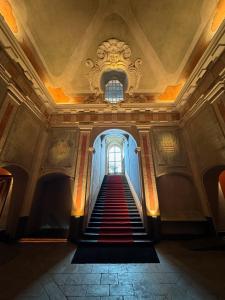 热那亚Hotel Palazzo Durazzo Suites的走廊,带楼梯,位于带窗户的大楼内