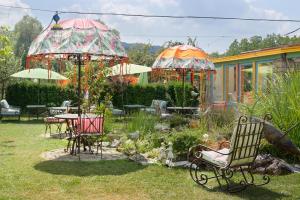 奥雷沙克Hotel Casa Art的花园配有桌椅和遮阳伞。