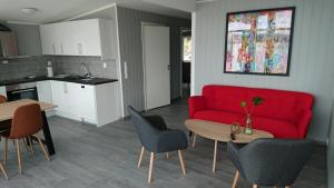 OffersøyaLofothytter的客厅配有红色的沙发和桌子
