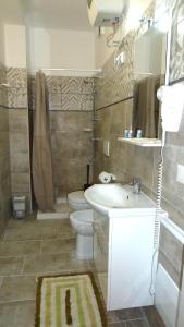 新福卡Regina Isabella Rooms的一间带水槽、卫生间和镜子的浴室