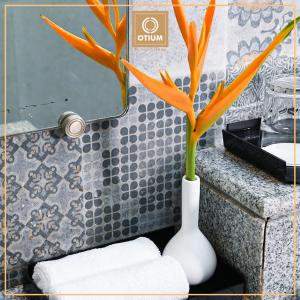 波尔沃林Otium Goa Resort by The Oterra的浴室里一个白色花瓶,上面有植物