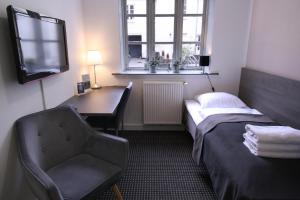 奥胡斯奥尔胡斯城市公寓酒店的客房设有书桌、床和椅子。