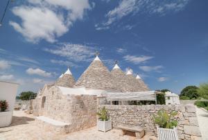 塞尔瓦迪法萨诺Nina Trulli Resort的一座蓝色天空的大石头建筑