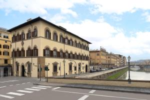 佛罗伦萨Leone Blu Suites | UNA Esperienze的河边街道上的建筑物