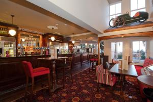 大莫尔文The Foley Arms Hotel Wetherspoon的餐厅内带红色椅子和桌子的酒吧