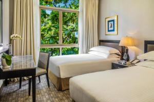 新加坡Treetops Executive Residences的酒店客房设有两张床和窗户。