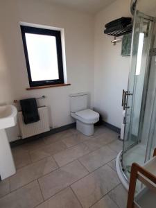 斯奇博瑞恩Roaringwater Stay的一间带卫生间、水槽和窗户的浴室