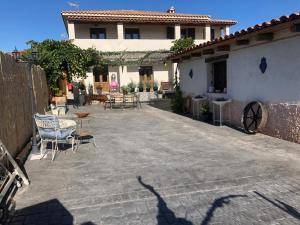 Torremocha de JaramaLos Diezmos的房屋前方设有带桌椅的庭院。