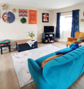 巴利纳Unboring Holiday Let, Ballina, Mayo的客厅配有蓝色的沙发和电视