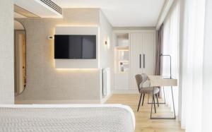 圣塞瓦斯蒂安Hotel Ilunion San Sebastián的一间卧室配有一张床,墙上配有电视
