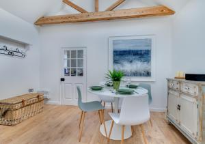 AldertonSpring House Studio的一间配备有白色桌椅的用餐室