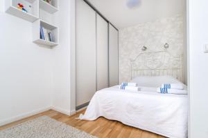 维尔纽斯Angel House Vilnius, Skroblu 39的白色卧室配有白色的蓝色调床