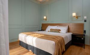 亚历山德鲁波利斯阿格洛斯酒店的一间卧室配有一张大床,床上有毯子