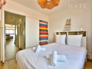 莱萨布勒-多洛讷Appartement au pied de la plage, vue imprenable sur la mer的卧室配有带毛巾的大型白色床