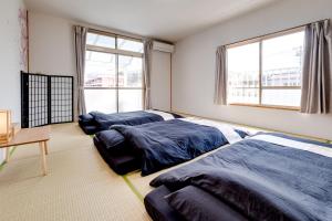 松本Forest Agata的一间卧室设有两张床、一张桌子和窗户。