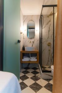 亚历山德鲁波利斯阿格洛斯酒店的一间带水槽和镜子的浴室