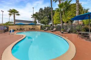 圣易西铎贝斯特韦斯特美洲酒店的一个带椅子和遮阳伞的大型蓝色游泳池